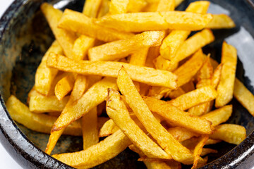 A bowl of freshly fried golden French fries, crispy on the outside and fluffy inside. A classic...
