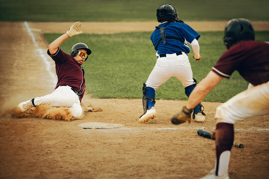 Exciting baseball game action with player sliding into home base