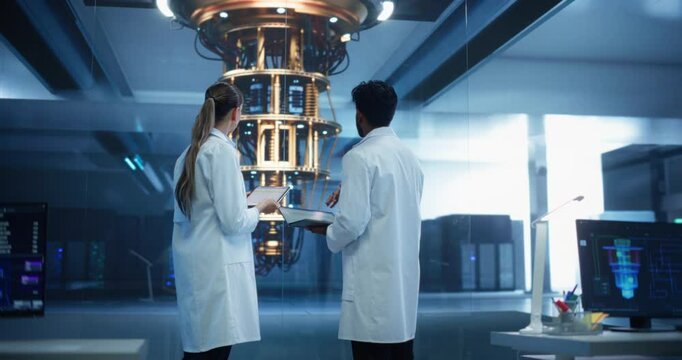 Portrait of Two Engineers Developing a High Tech Quantum Processor. Diverse Young Male and Female Scientists Using a Tablet Computer and Discussing the Project in a Research Facility