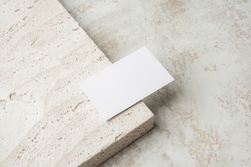 Blank white business card mockup displayed on minimalist natural stone surface