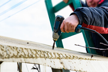 Man inspects old greenhouse for renovation on a spring day, greenhouse repair. Removal old...