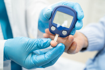 Doctor check diabetes from finger blood sugar level with finger lancet.