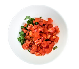 Sliced tomato and green basil in white bowl on white background