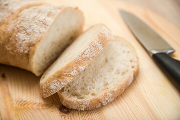 Slices of ciabatta lie on a wooden board