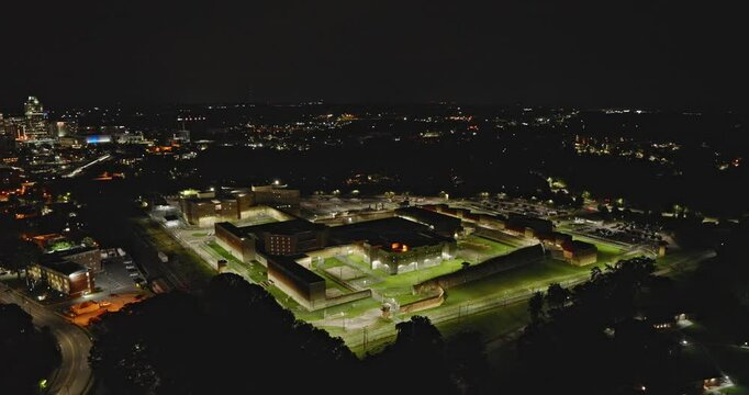 Raleigh North Carolina Aerial v43 flyover Morehead School and Dix Park, circling the perimeter of Central Prison with downtown night cityscape in the distance - Shot with Inspire 3 8k - Sept 30th 2023
