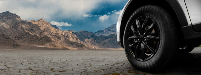 A black tire is on a rocky road in front of a mountain © Кристина Пахомова