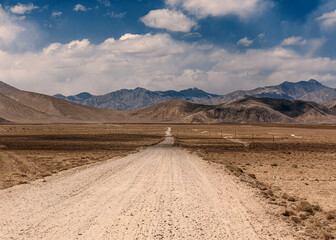 A road in the desert with mountains in the background