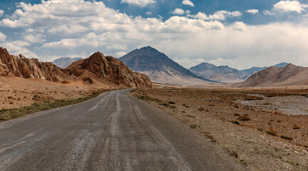 A road in the desert with mountains in the background