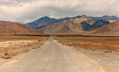 A road in the desert with mountains in the background