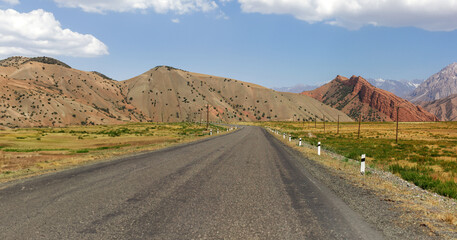 A road in the desert with a mountain in the background