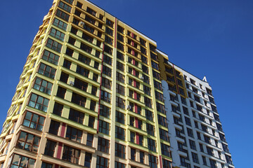 Gazing upward at three towering buildings set against a clear blue sky