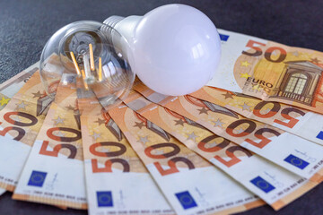 Expensive bills. Light bulb with banknotes indicate inflation and rising electricity bills....