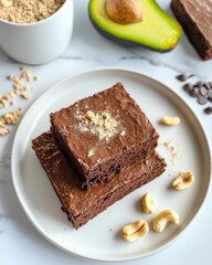 Rich chocolate brownies stacked on plate, garnished with nuts an