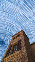 Long star trails fill the night sky circling over a traditional pigeonnier tower in the Dordogne...