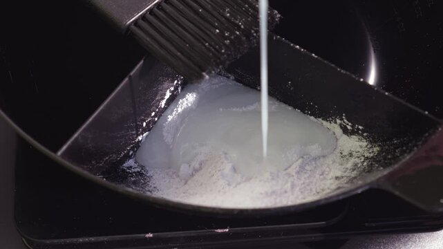 Falling oxidizer into powder or hair lightening dye close-up