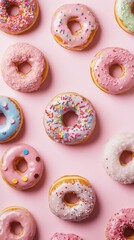 Several colorful frosted donuts arranged on a pastel pink background