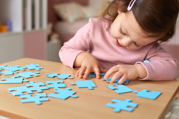 Cute little child girl doing puzzle at home, children development