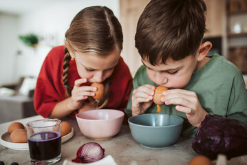 Siblings preparing egshells for easter egg decorating.
