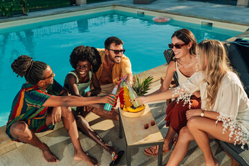 Friends toasting colorful drinks at poolside party