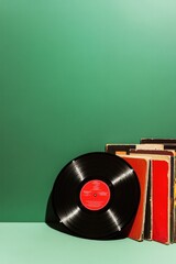Classic vinyl record rests beside colorful album covers on vibra