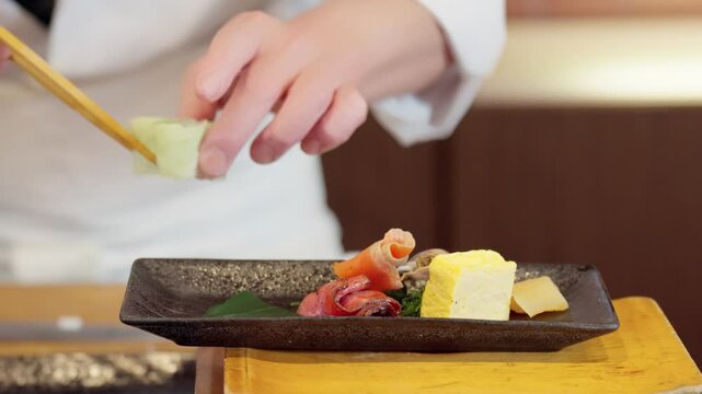 料理を盛り付ける料理人の手元