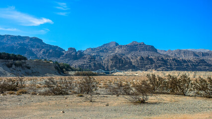 desert landscape dry land country side panorama rocky canyon mountain ridge background with small bridge along it