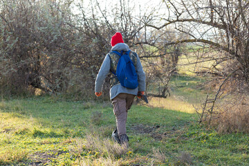 Mature hunter man holding a shotgun and walking through a field