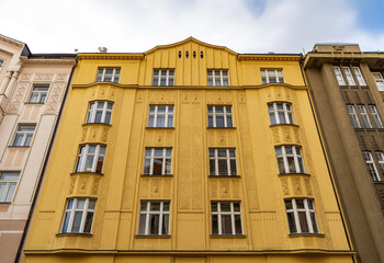 There stands a large yellow building featuring a plethora of windows
