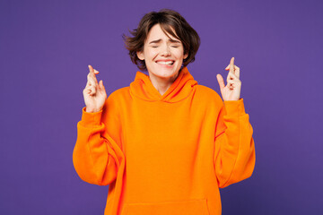 Young smiling happy Caucasian woman she wear orange hoody casual clothes waiting for special...
