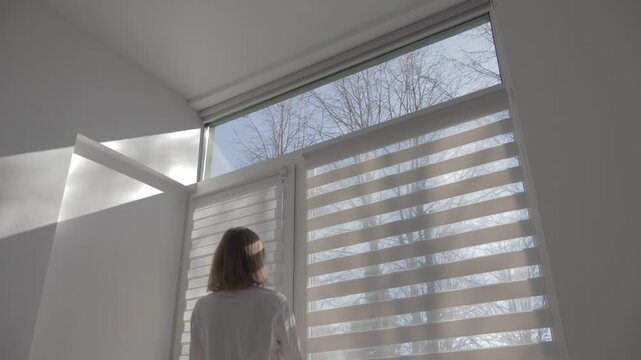Woman closing and opening modern room blinds with lighting range control. 4k footage.