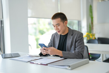 Fototapeta premium Asian Businessman with Smartphone&nbsp;working mobile devices cell telephone technology e-commerce smartphone business professional investor working new start up project