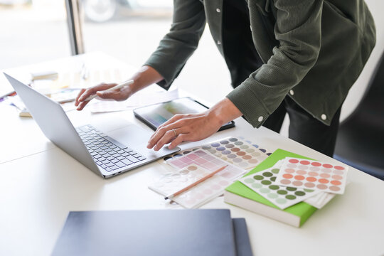 Business asian Man Artist Creative Designer sketch graphic drawing on graphic laptop and Color swatch samples Concept of idea creativity