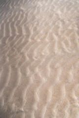 Wind creating ripples on beach sand texture background