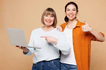 Elder parent mom 50s years old young adult daughter two IT women together wear casual clothes hold...