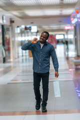 Cheerful facial expression. Black man is in the hall of the supermarket