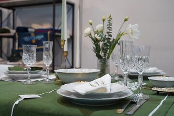 Glasses, plates and cutlery on the tablecloth.