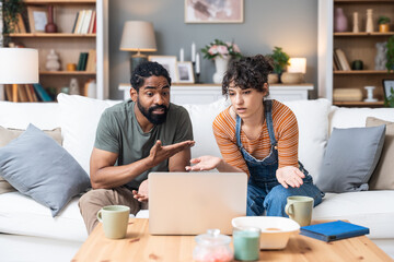 Relationship difficulties, communication problems. Young couple sitting at home having online...