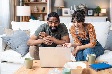 Relationship difficulties, communication problems. Young couple sitting at home having online therapy with psychotherapist on video call on laptop computer. Man and woman talking to therapist.