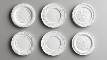 Elegant arrangement of nine porcelain plates in 3x3 grid, intricate relief patterns featuring floral motifs, baroque scrollwork, geometric borders, pure white ceramic against neutral grey backdrop,