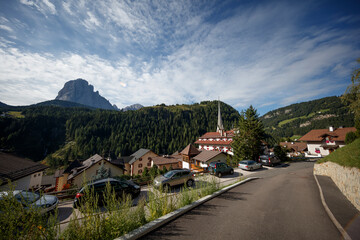 Naklejka premium Relaxing village atmosphere in the Dolomites with stunning mountain backdrop and clear skies