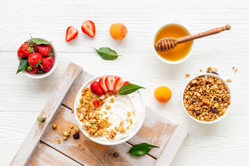 Healthy breakfast flat lay. Yogurt with muesli and strawberry in bowl. Top view