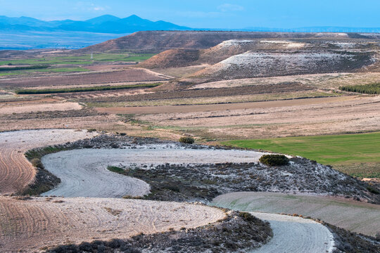 Meandering riverbed carving through an arid valley, displaying natural erosion patterns and land texture.
