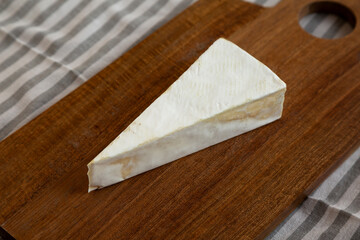 Organic Homemade White Brie Cheese on a Wooden Board, side view.