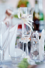 Elegant Champagne Glass Decorated With Ribbon at a Wedding Table Setting..