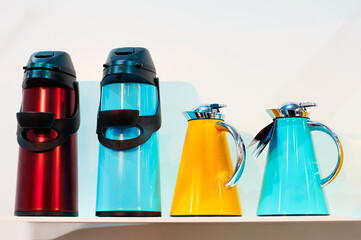 Colorful Thermal Flasks And Coffee Carafes Arranged on White Background..