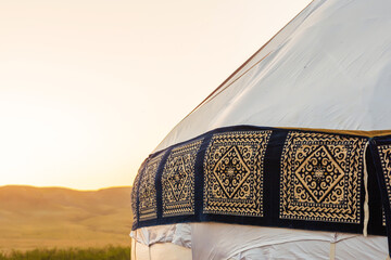 Kazakh yurt on the background of sunset in a field. Kazakh Muslim roundhouse in the steppe