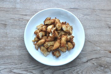 fried slice chicken meat with salt and garlic on plate