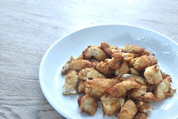 fried slice chicken meat with salt and garlic on plate
