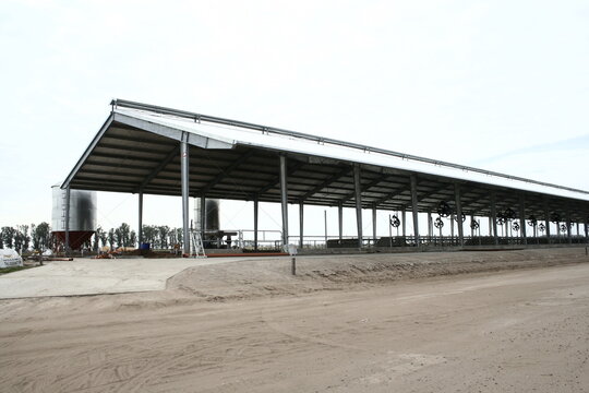 Cobertizo de metal para almacenar a las vacas lecheras de un tambo rob&oacute;tico en el campo rural, forma un dise&ntilde;o de arquitectura de avanzada.