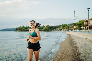 Young caucasian woman run or jog on the beach at sunset	